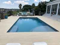 Rectangular fiberglass pool with turquoise water in a tropical backyard