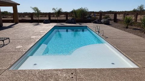 Finished fiberglass pool with integrated spa in a sunny backyard