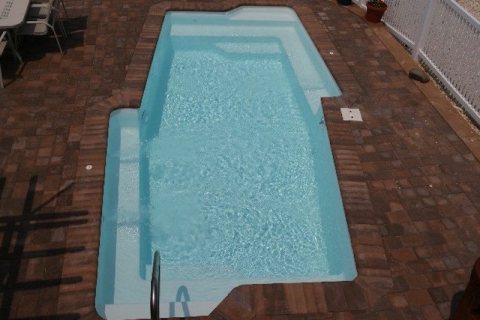 San Juan fiberglass in‑ground pool in a bright backyard