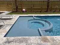 San Juan fiberglass pool in a backyard with clear turquoise water