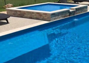 Fiberglass pool and spa in a sunny backyard